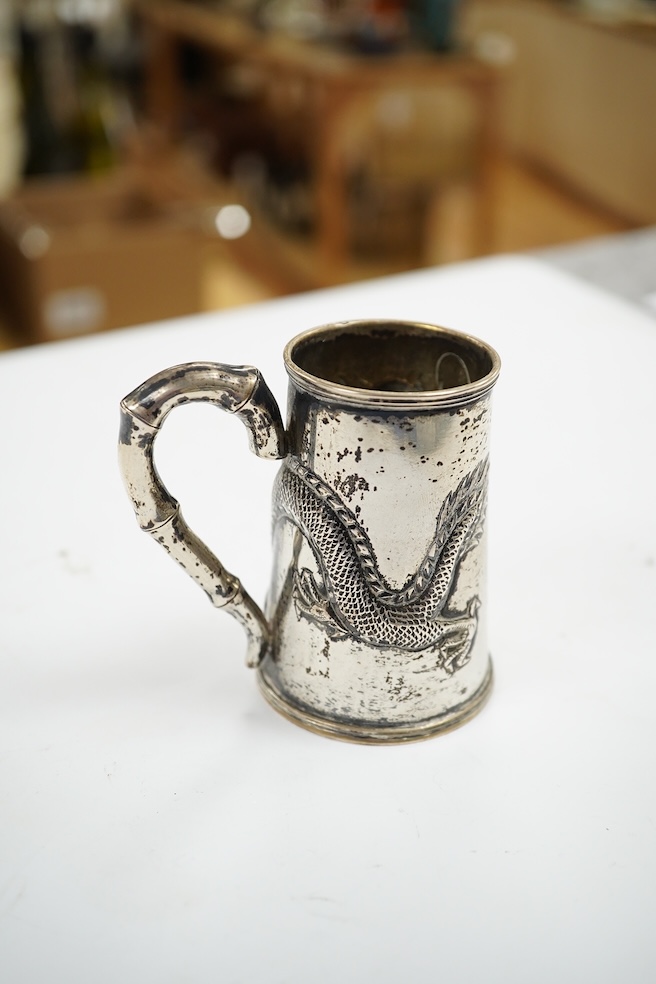 A small Chinese Export white metal mug, embossed with a dragon, 68mm, 66 grams. Condition - fair